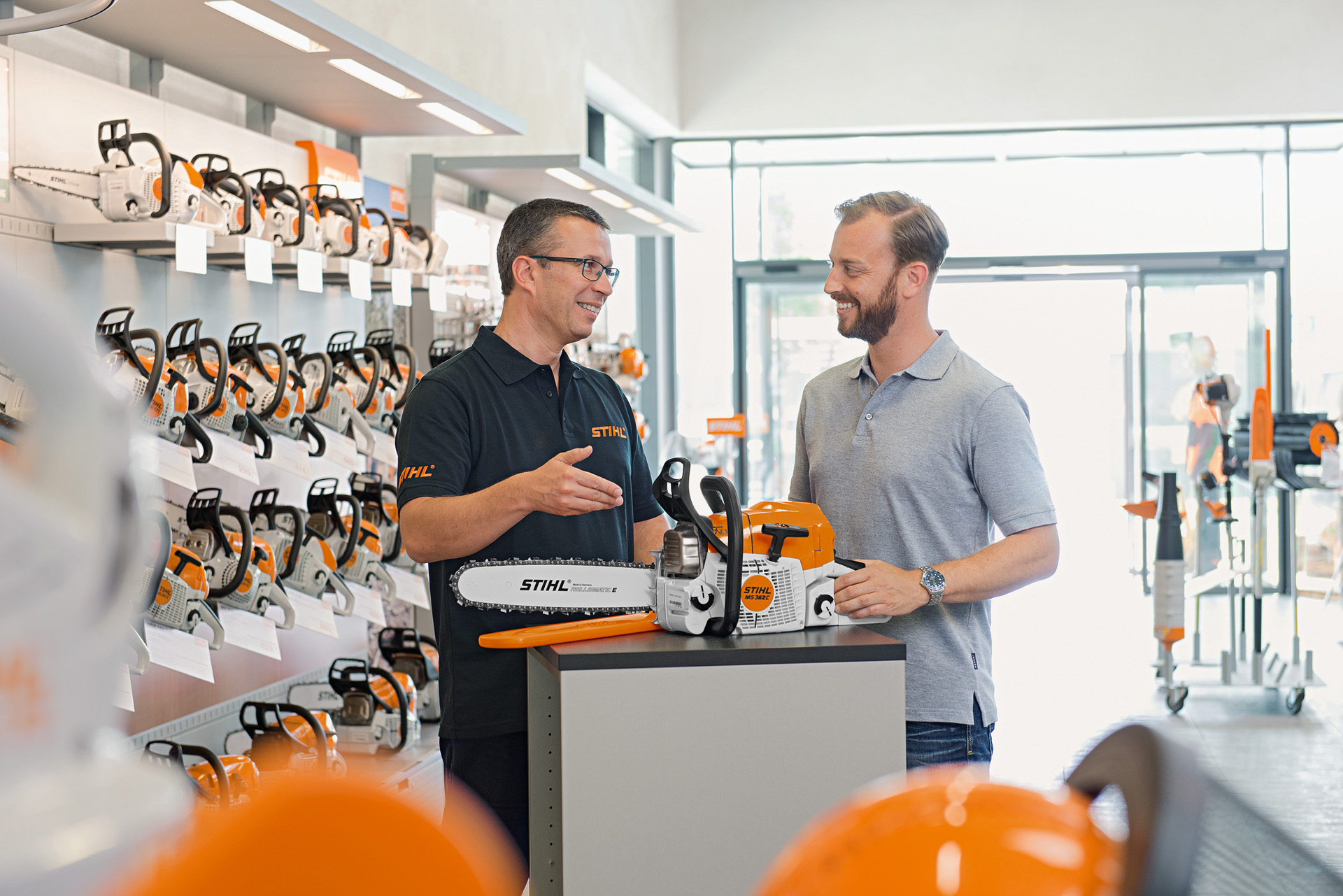 Un distribuitor STIHL consiliază un tânăr la cumpărarea unui motoferăstrău STIHL