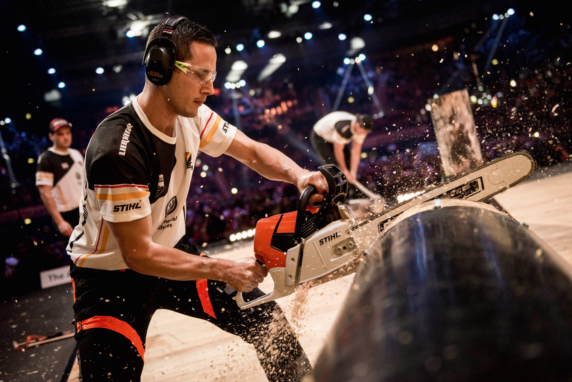 STIHL TIMBERSPORTS® Un atlet taie cu fierăstrăul un trunchi de copac la o competiție 