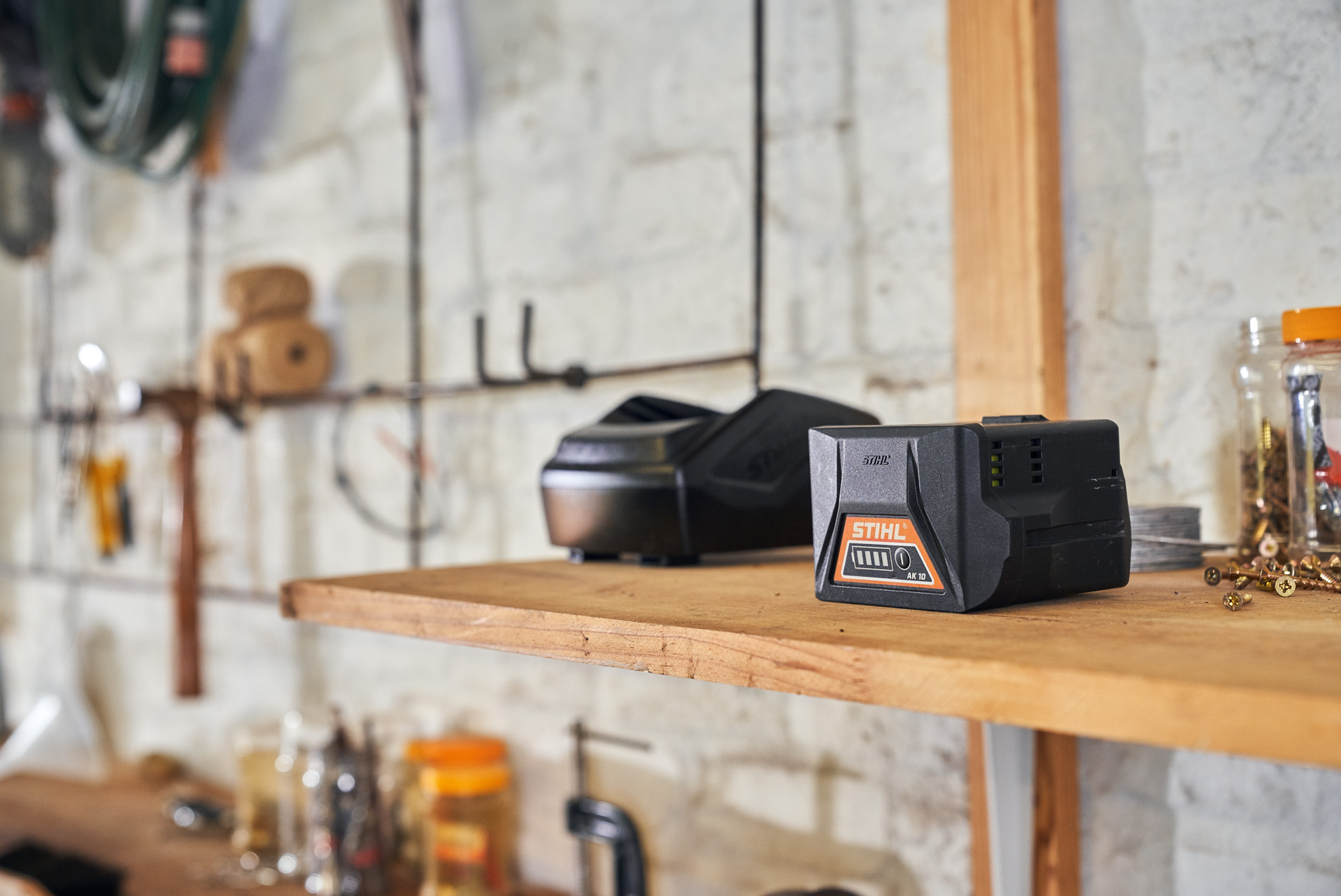 Doi acumulatori cu tehnologia acumulatorilor STIHL așezaţi pe un raft într-un atelier