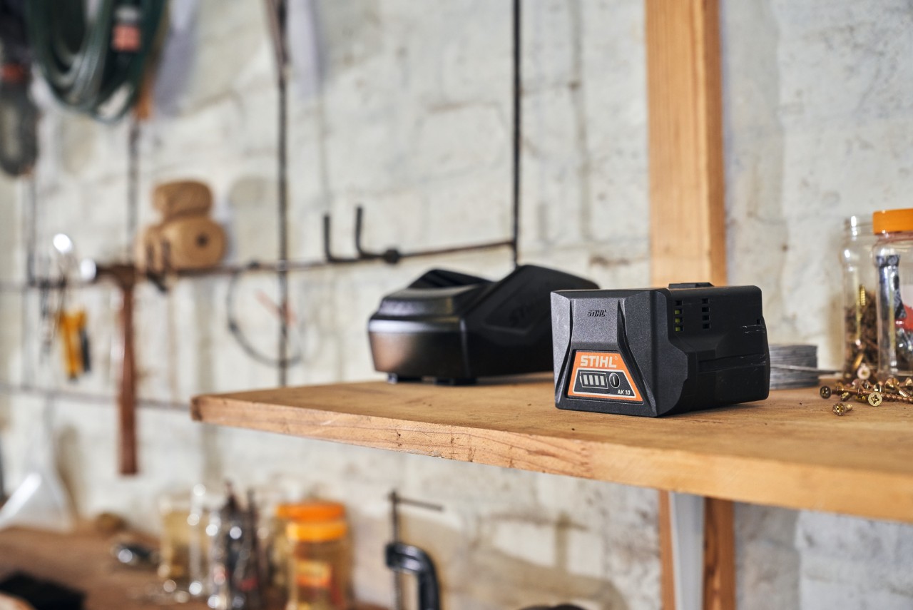 Doi acumulatori cu tehnologia acumulatorilor STIHL așezați pe un raft într-un atelier