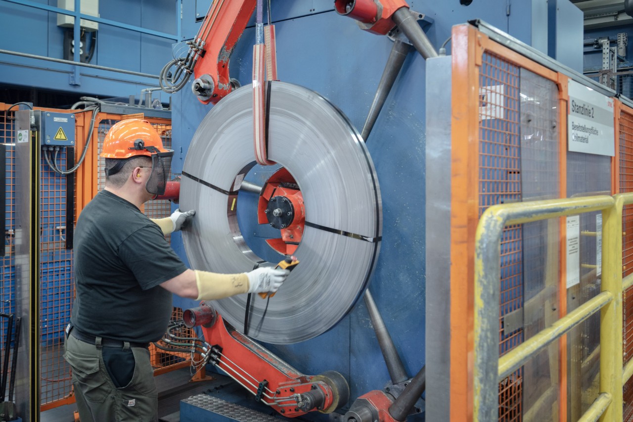 Un bărbat în echipament de protecție lucrează la o mașină pentru fabricarea șinelor port-lanț la STIHL 
