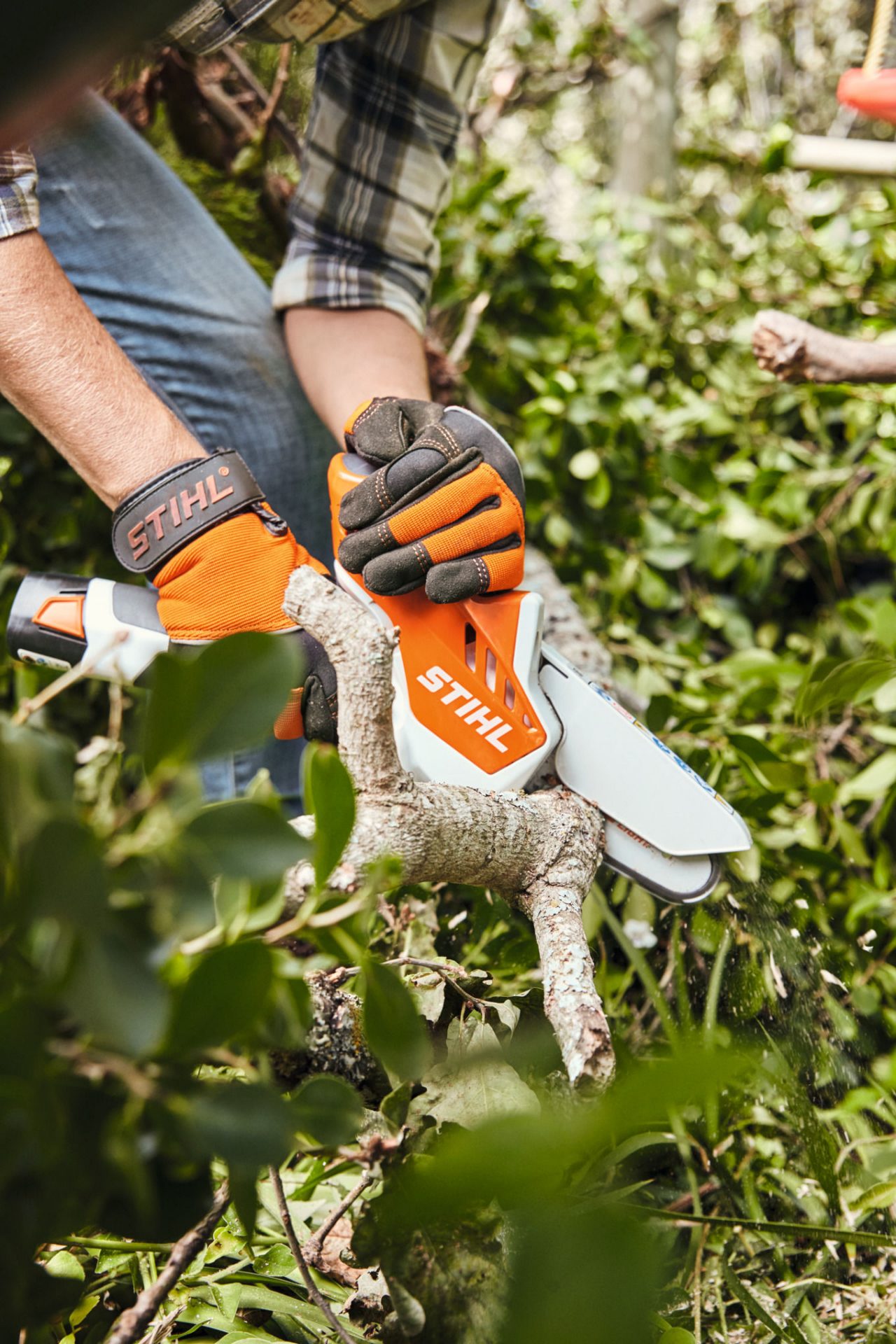 Lemnul unui gard viu este tăiat cu ajutorul utilajului de tăiat material lemnos cu acumulator STIHL GTA 26